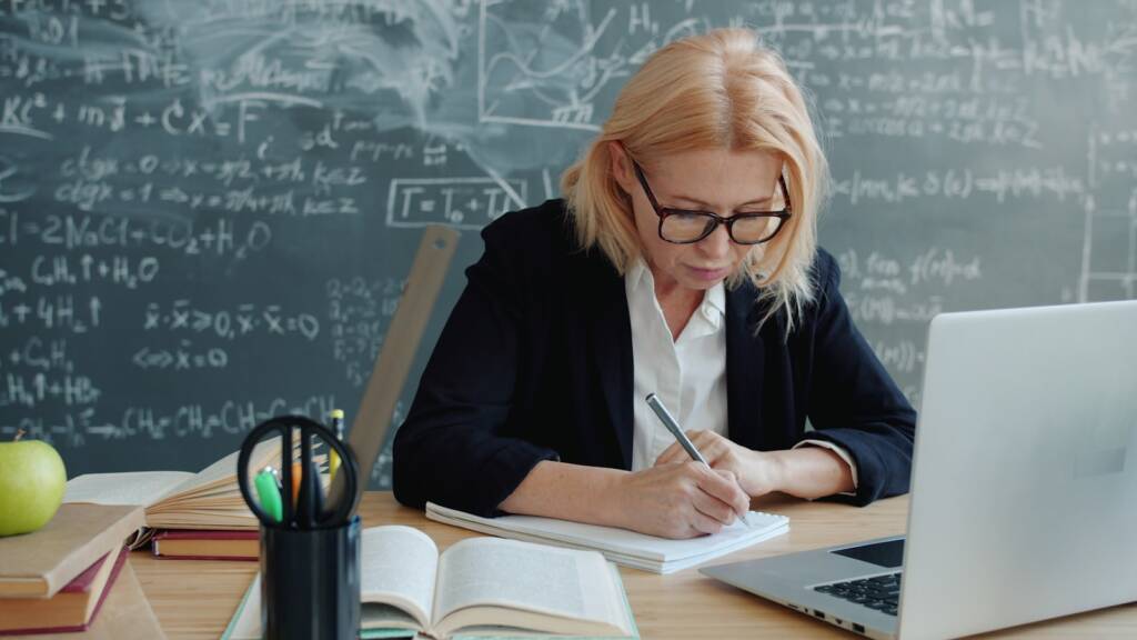 Adulte étudiant l’anglais avec un ordinateur et un cahier
