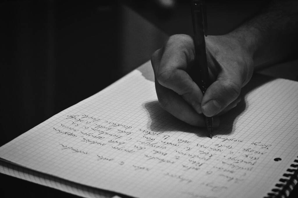 Personne écrivant une lettre dans un cahier